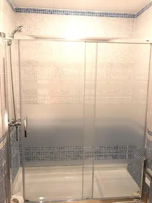 a shower with a glass door in a bathroom at NEW! Cute apartment near metro in Barcelona