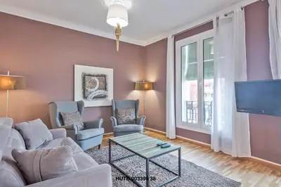 a living room with a couch and chairs and a tv at Alcam Urgell in Barcelona