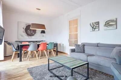 a living room with a couch and a table and chairs at Alcam Urgell in Barcelona