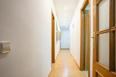 a hallway with an open door and wooden floors at Alcam Calabria in Barcelona