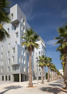 a building with palm trees in front of it at Lugaris Beach Apartments in Barcelona