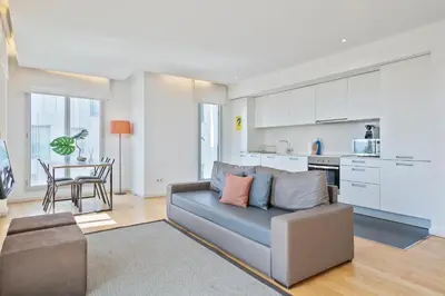 a living room with a couch and a kitchen at Lugaris Beach Apartments in Barcelona