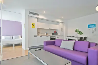a living room with a purple couch and a table at Lugaris Beach Apartments in Barcelona