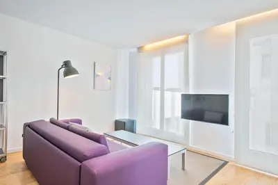 a living room with a purple couch and a table at Lugaris Beach Apartments in Barcelona