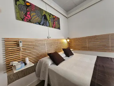 a bedroom with a bed with a wooden headboard at Hotel Palermo in Barcelona