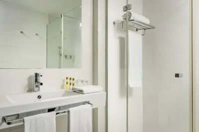 a white bathroom with a sink and a shower at Ikonik Lex in Hospitalet de Llobregat