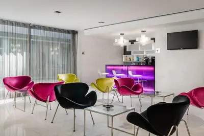 a living room with pink and yellow chairs at Ikonik Lex in Hospitalet de Llobregat