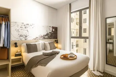 a bedroom with a large white bed and a window at Aspasios Poble Nou Apartments in Barcelona