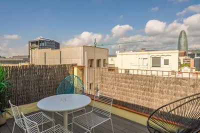 a patio with a table and chairs on a roof at Aspasios Poble Nou Apartments in Barcelona