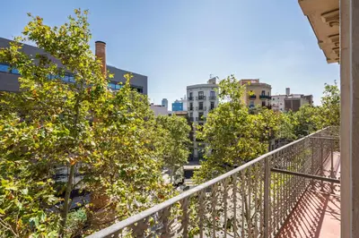 a balcony with trees and buildings in the background at Aspasios Poble Nou Apartments in Barcelona
