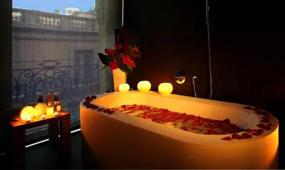 a bath tub with candles in a room with a window at Ohla Barcelona in Barcelona