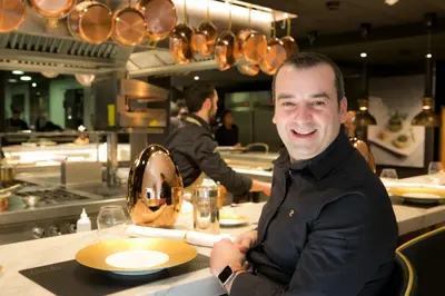 a man sitting at a counter in a kitchen at Ohla Barcelona in Barcelona