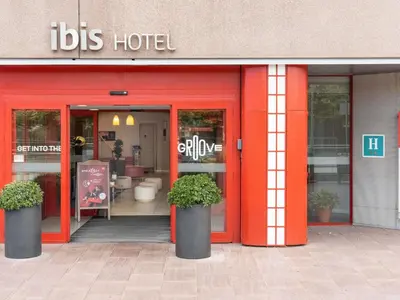 a restaurant with orange doors and plants in front of it at Ibis Barcelona Meridiana in Barcelona