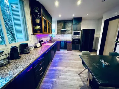 a large kitchen with blue cabinets and a table at Les Canyes Cottage, Private Villa Resort in Piera