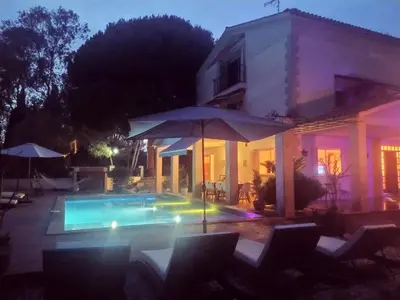 a swimming pool with an umbrella next to a house at Les Canyes Cottage, Private Villa Resort in Piera