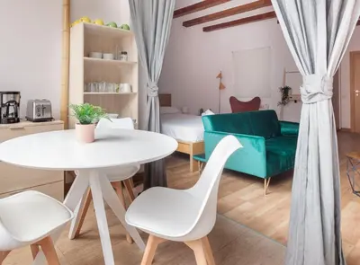 a living room with a white table and a green couch at Spacious doubleroom apartment at Sants in Barcelona