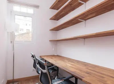 a home office with a wooden desk and a chair at Spacious doubleroom apartment at Sants in Barcelona