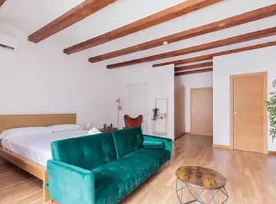 a green couch in a bedroom with a bed at Spacious doubleroom apartment at Sants in Barcelona