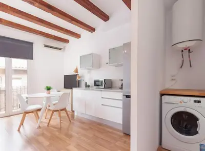 a kitchen and dining room with a table and a washing machine at Spacious doubleroom apartment at Sants in Barcelona
