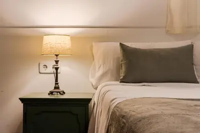 a bedroom with a bed and a lamp on a night stand at Magalhaes · Trad flat in Poble Sec, near ramblas in Barcelona