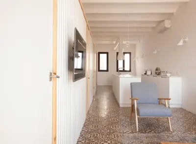 a hallway with a blue chair and a kitchen at Pere IV · New & modern apartment close to beach in Barcelona