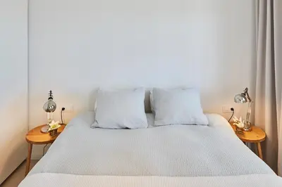 a bedroom with a bed with two lamps on two tables at Sunny Beachfront Escape in Castelldefels