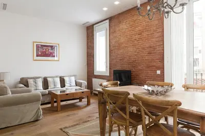 a living room with a brick wall and a table and chairs at Akira Flats Roger de Flor Chic apartment in Barcelona