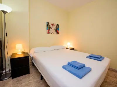 a bedroom with a large white bed with blue towels on it at Apartment Vila Olímpica- Sant Martí - Sardenya by Interhome in Barcelona