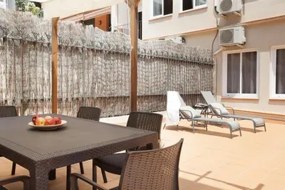 a patio with a table and chairs with a bowl of fruit on it at EasySleep Eixample in Barcelona