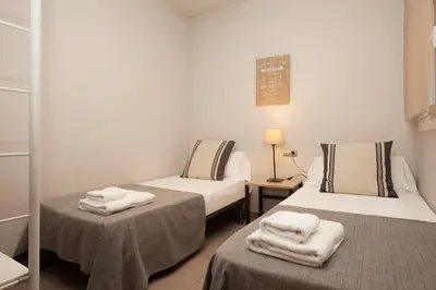 a room with two beds with towels on them at EasySleep Eixample in Barcelona
