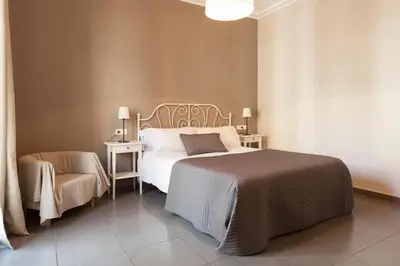 a bedroom with a large bed and a chair at EasySleep Eixample in Barcelona