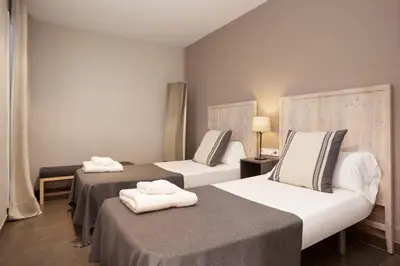 two beds in a hotel room with towels on them at EasySleep Eixample in Barcelona
