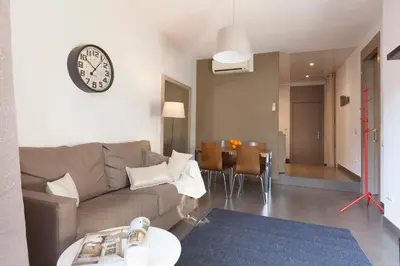 a living room with a couch and a clock on the wall at EasySleep Gaudi Terrace in Barcelona