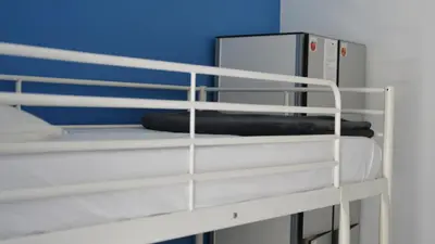 a white bunk bed with a blue wall at Paraiso Hostel in Barcelona