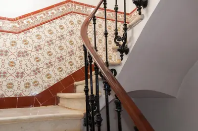 a staircase with an ornate tile wall at Hotel Cantón in Barcelona