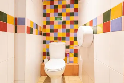 a bathroom with a toilet with colorful tiles on the wall at Mambo Tango in Barcelona