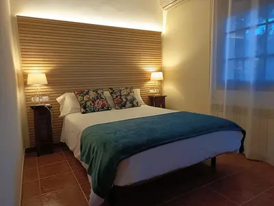 a bedroom with a large bed with a large window at Cal Músic B&B in Premia de Dalt