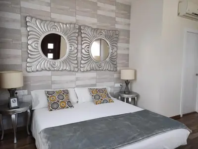 a bedroom with a large bed and two mirrors at Cal Músic B&B in Premia de Dalt
