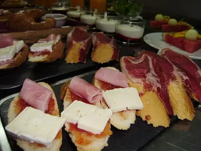 a bunch of bread with meat and cheese on a table at Cal Músic B&B in Premia de Dalt