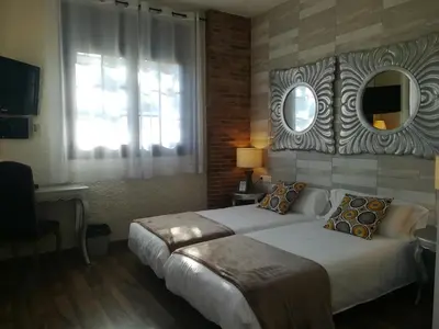 a bedroom with a large bed and a mirror at Cal Músic B&B in Premia de Dalt