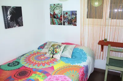 a bedroom with a colorful bed with pillows on it at Natura Fira Barcelona in Hospitalet de Llobregat