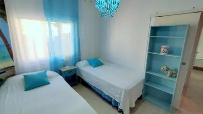 a small bedroom with two beds and a chandelier at Hawaii Fira Barcelona in Hospitalet de Llobregat