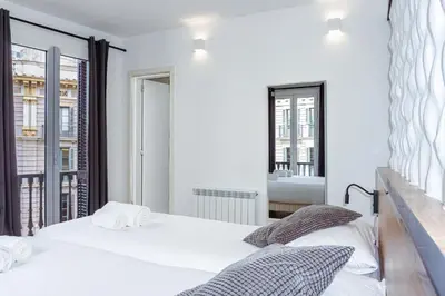 two beds in a room with a mirror at Fontanella Green House in Barcelona