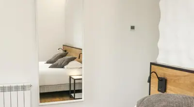 a bedroom with a mirror and a bed at Fontanella Green House in Barcelona