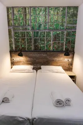 two beds in a room with a window at Fontanella Green House in Barcelona