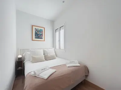 a white bedroom with a bed with two towels on it at Stay U-nique Apartments Urquinaona II in Barcelona