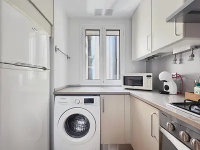 a kitchen with a washing machine and a microwave at Stay U-nique Apartments Urquinaona II in Barcelona