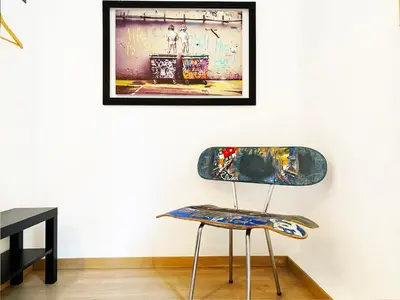 a chair in a room with a picture on the wall at Hostal Portugal in Barcelona