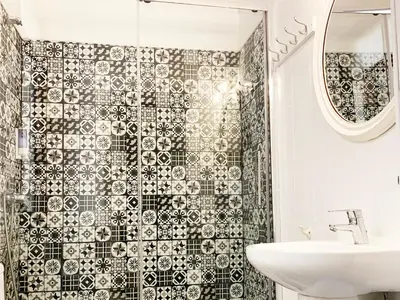 a bathroom with a black and white tiled shower at Hostal Portugal in Barcelona