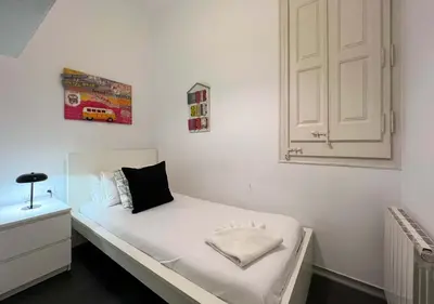 a small bedroom with a white bed and a cabinet at Stay Unique Apartments Cent in Barcelona